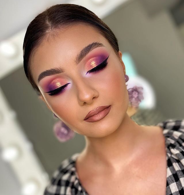 Mujer posando de frente con maquillaje de ojos color rosado