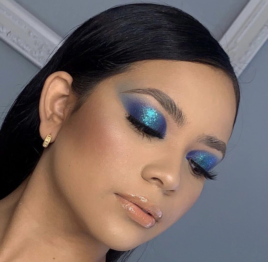 Mujer mostrando maquillaje de ojos en tonos azules