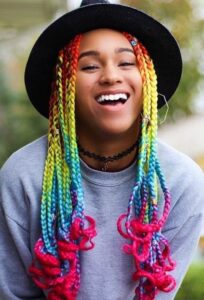 Mujer sonriente con unas trenzas de varios colores